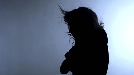 young female silhouette with hair blowing in the wind