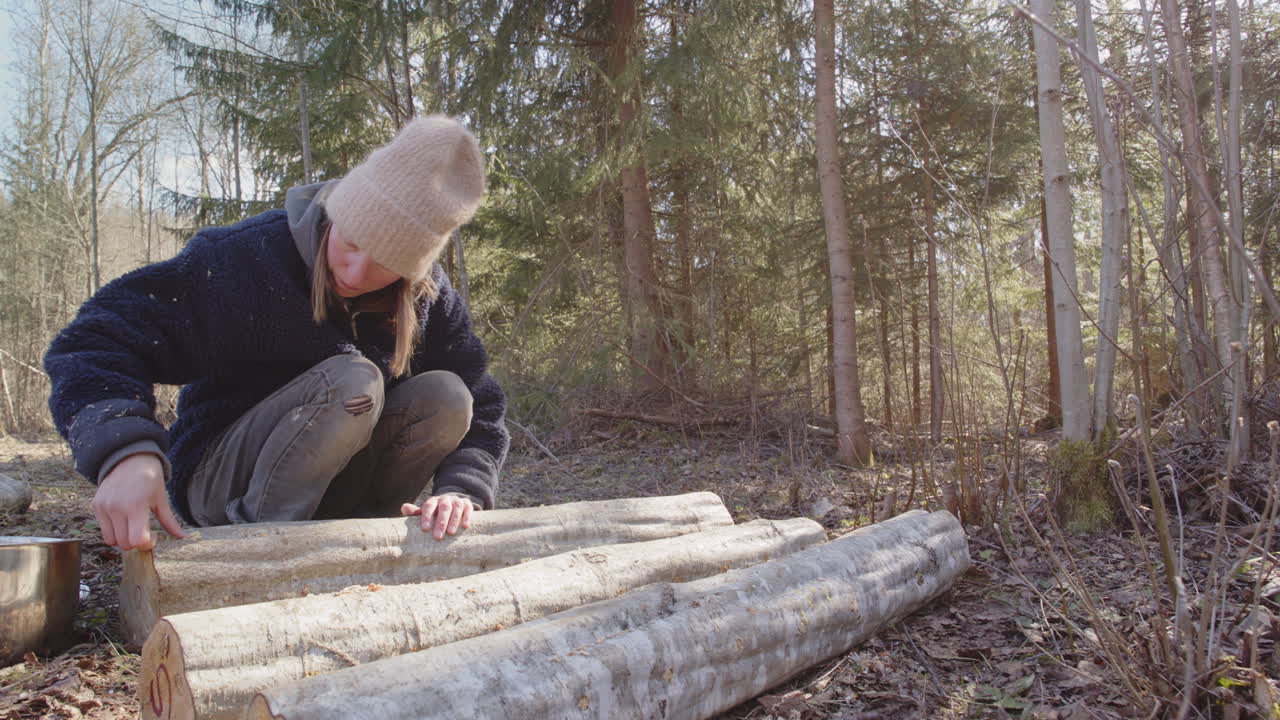 Swedish woman sealing plug spawn inoculation points on log with molten wax