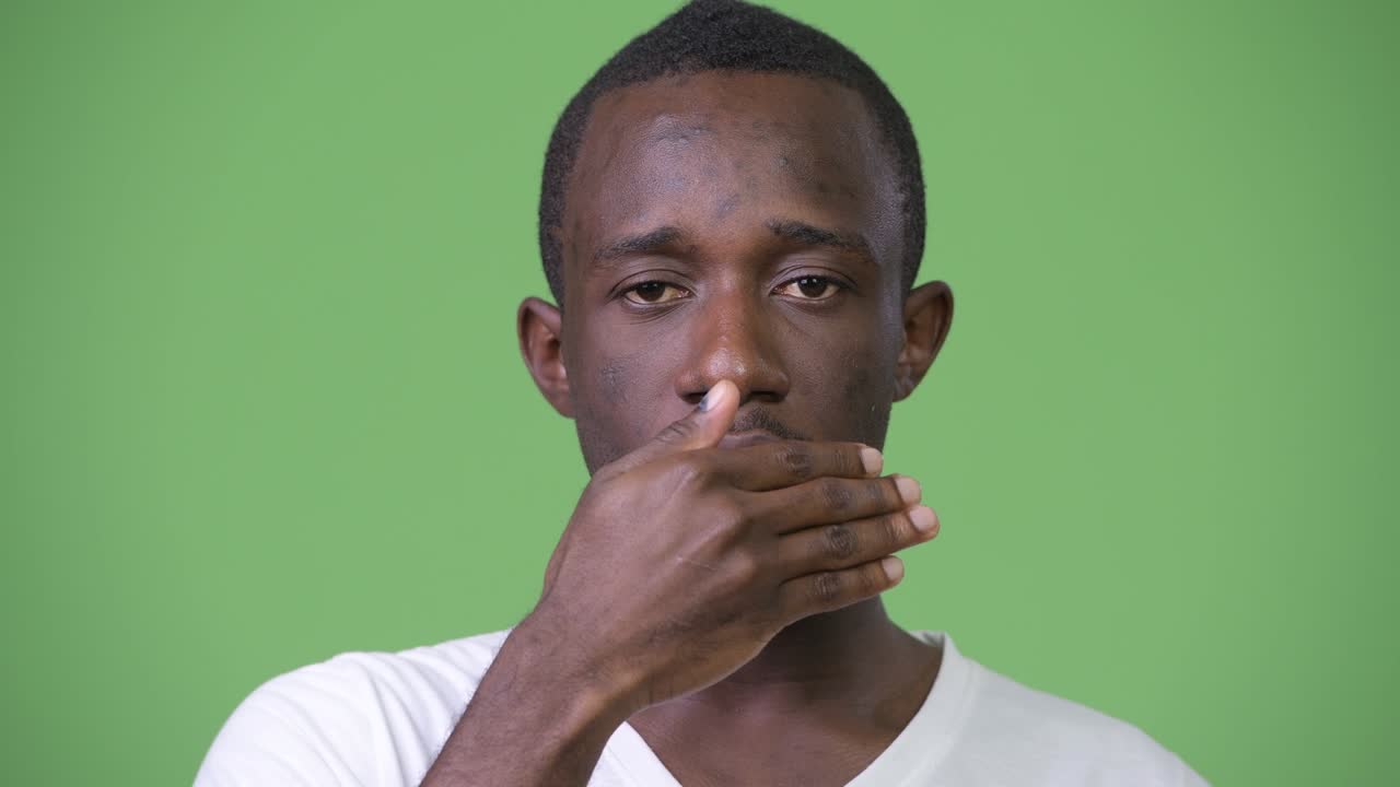 Young African man covering mouth as three wise monkeys concept