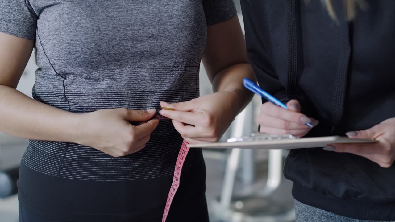 체육관 에서 허리 를 측정 하는 여자 의 클로즈업