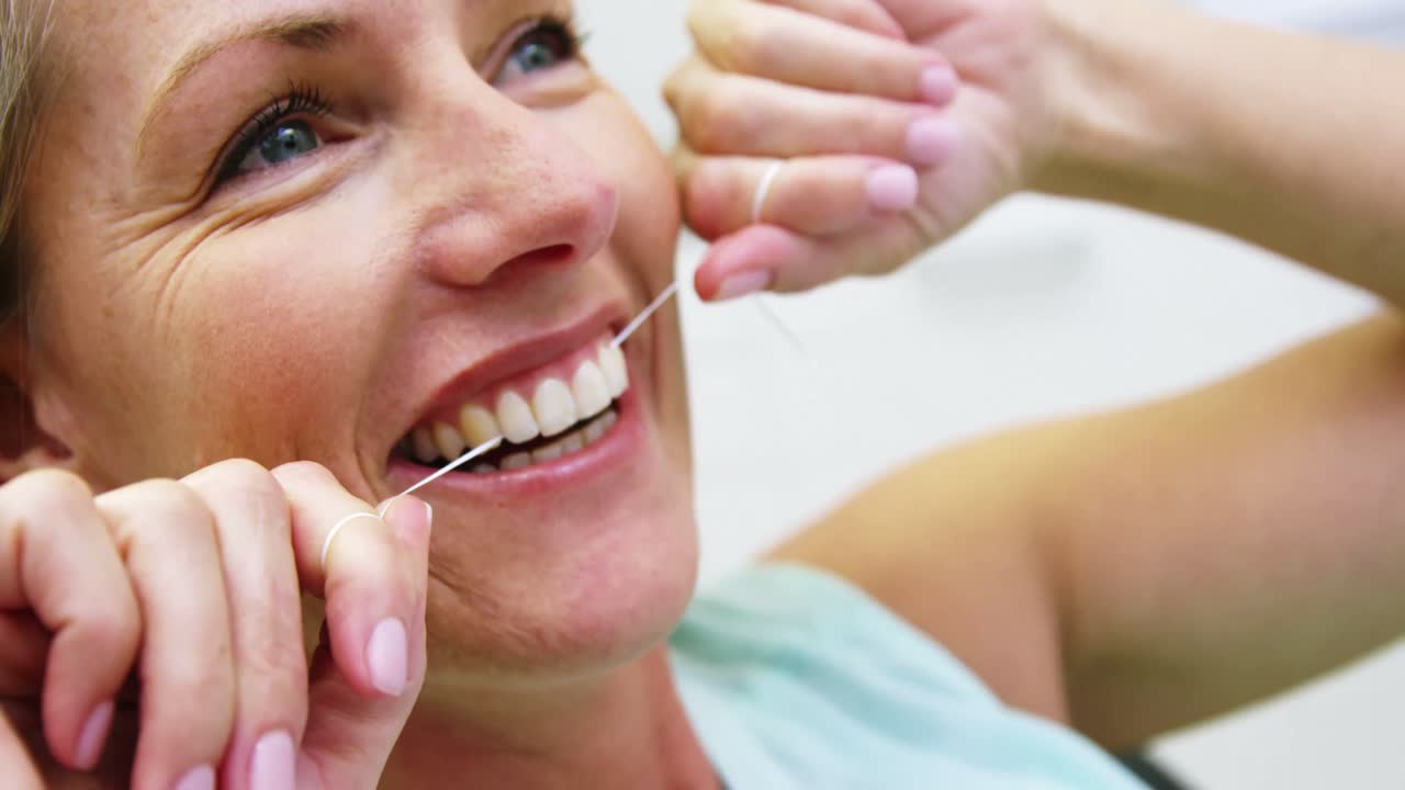 Woman flossing her teeth