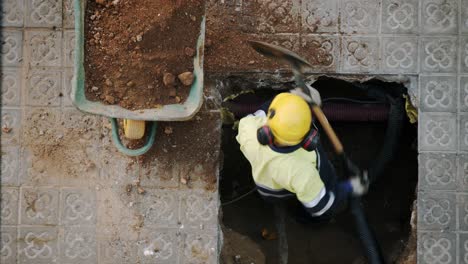 Top-View-Close-Up-Of-Constructor-Worker-Digging-Shoveling-and-Breaking-a-Concrete-on-a-street-in-Barcelona