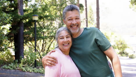 Feliz-Pareja-De-Ancianos-Birraciales-Abrazándose-En-El-Soleado-Jardín