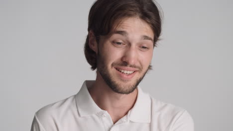 caucasian man in front of camera on gray background.