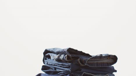 close up of folded jeans with different shades on white background with copy space