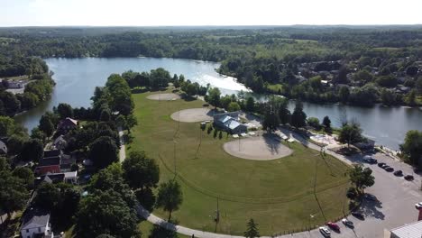 drone flying over a park by a lake at sunrise