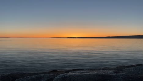 time lapse shot of orange sunset taken from coastline during evening.