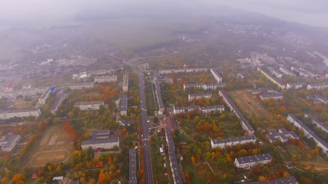 Hazy view of urban landscape on dull autumn day. Circling footage over the residential districts of provincial city.