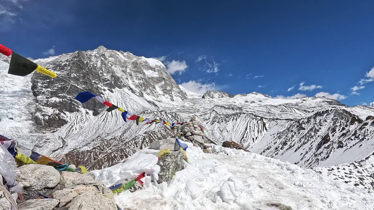 coloridas banderas de oración tibetanas en un panorama impresionante desde kyanjin ri, con vistas a los serenos picos cubiertos de nieve del pico yala y el pico langtang