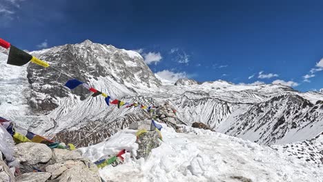 Colourful-Tibetan-prayer-flags-in-a-Breathtaking-panorama-from-Kyanjin-Ri,-overlooking-the-serene-snow-covered-peaks-of-Yala-Peak-and-Langtang-Peak