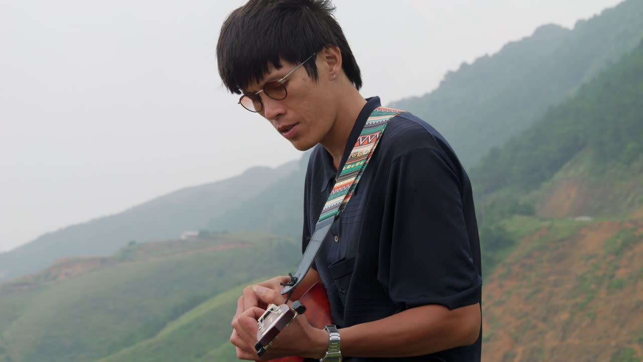 우쿨 ⁇ 레 를 연주 하는 음악가 의 가까운 측면 전망