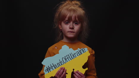 sad homeless child girl protesting war conflict raises banner with inscription hands off ukraine