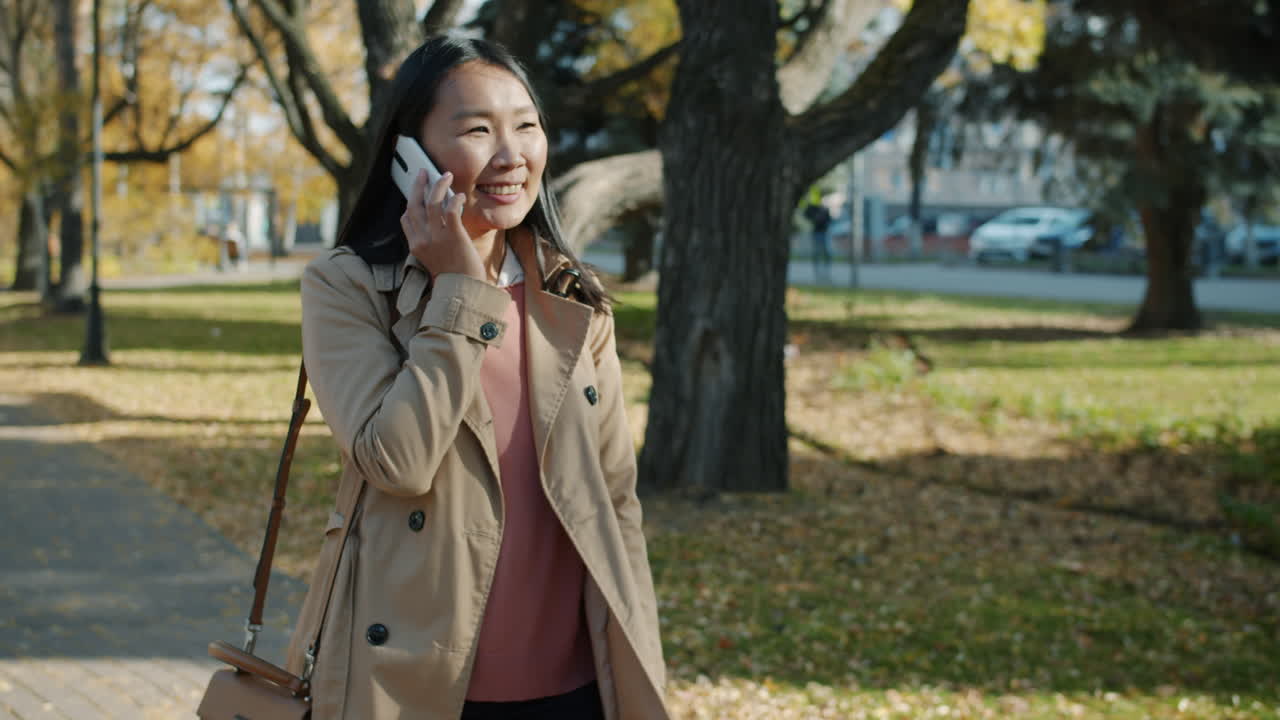 Woman Talking on Phone in Autumn Park