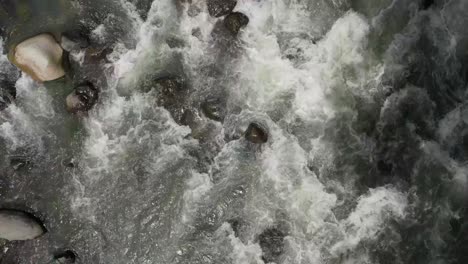 White-water-rapids-flowing-quickly-down-a-rocky-riverbed