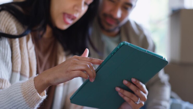 Couple, hands and with tablet in new house