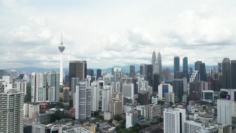 aerial drone shot of kl tower and petronas twin towers in kuala lumpur, malaysia