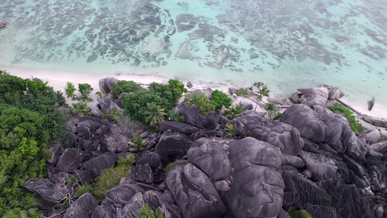 Rekaman drone pantai pasang surut yang spektakuler dan batu granit Anse Source d'Argent, La Digue, Seychelles 018 30fps