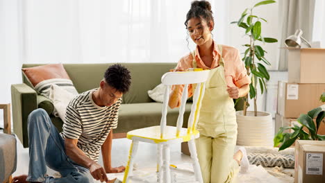 couple painting a chair in their new apartment