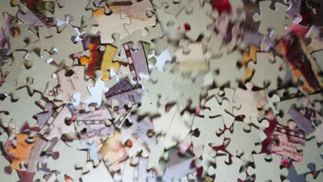 Puzzle pieces scattered on the glass and a hand looking for the right piece