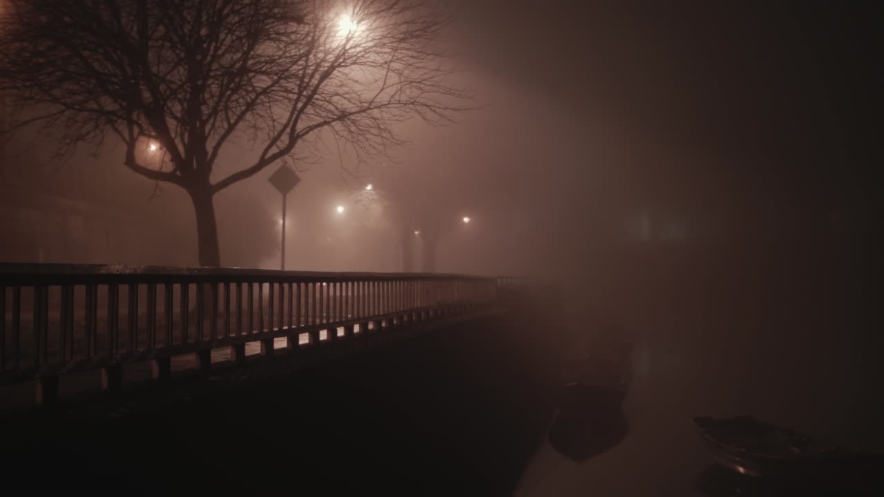 Atmospheric scene riverside cars drive through thick fog