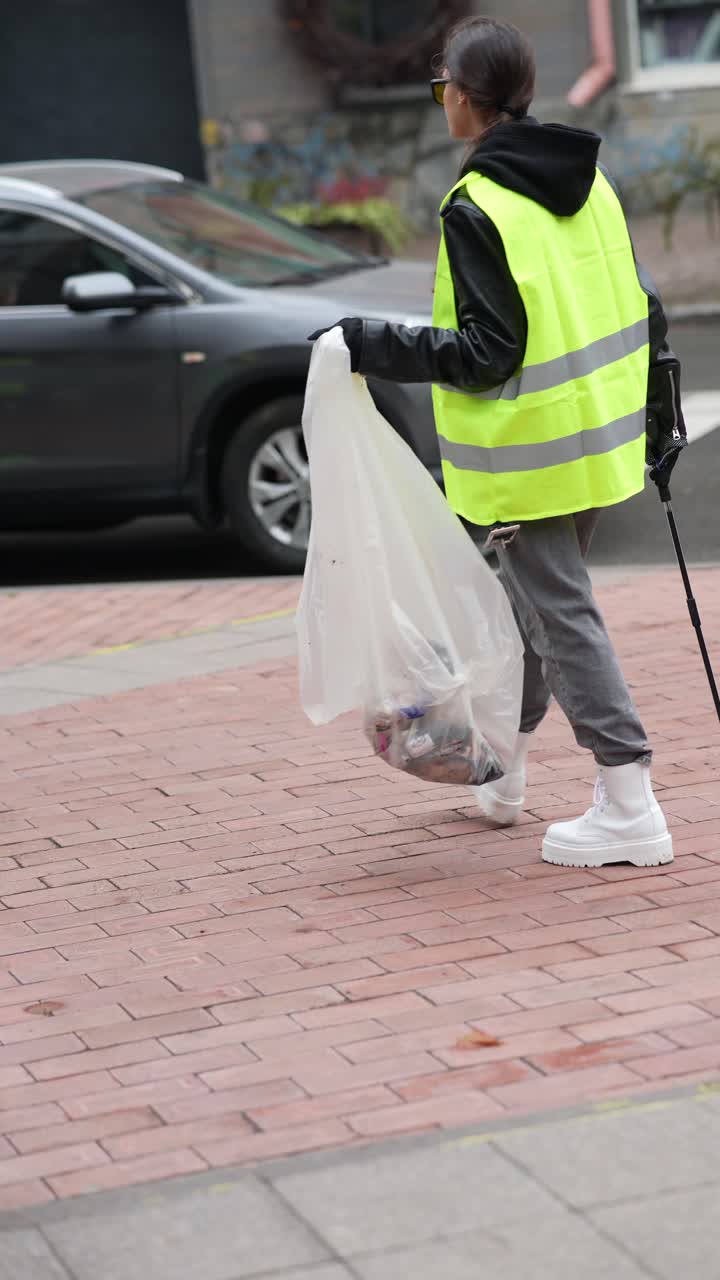 mujer limpiando la basura en la calle