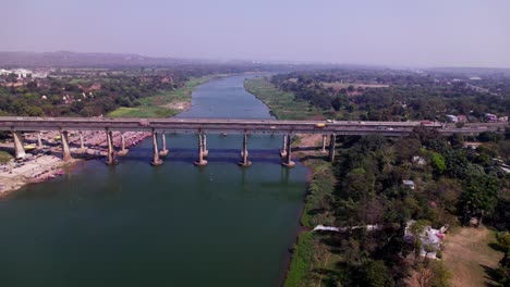 aerial view of narmada river with tilwara bridge and greenery at day time, push in, pan shot, drone shot, 4k.