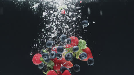 video of berries falling underwater with copy space on black background