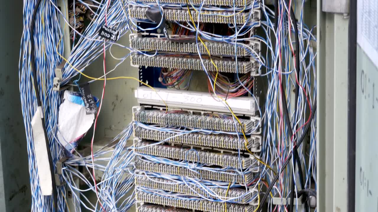 centralita eléctrica no en funcionamiento con cables de red y telefónicos sobresalientes en la calle