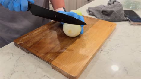 slicing a raw onion on a cutting board