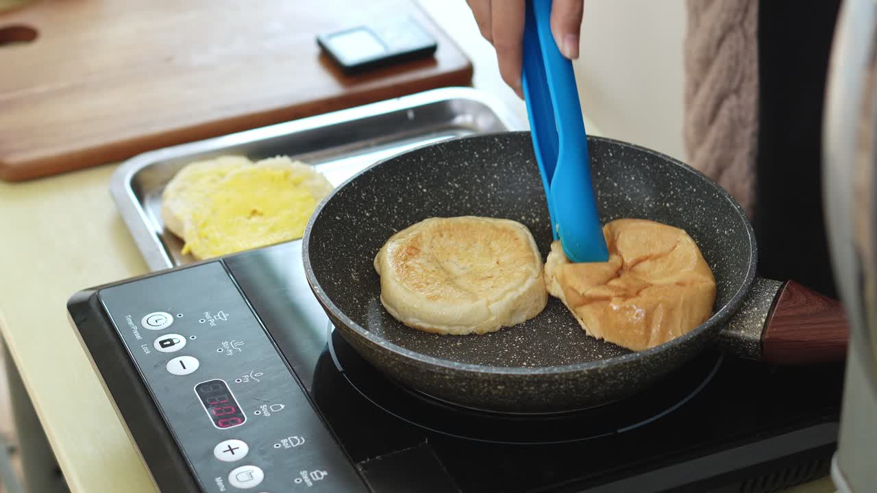 Woman Heating Bun Using Tongs On Hot Pan For Making Chicken Cheese Burger