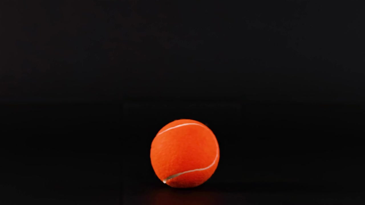 A series of frames showing an orange tennis ball on a dark surface, highlighting its movement and position.