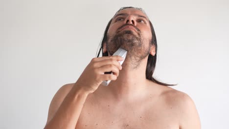 latin-long-hair-man-shaving-with-electric-shaver,-electric-razor