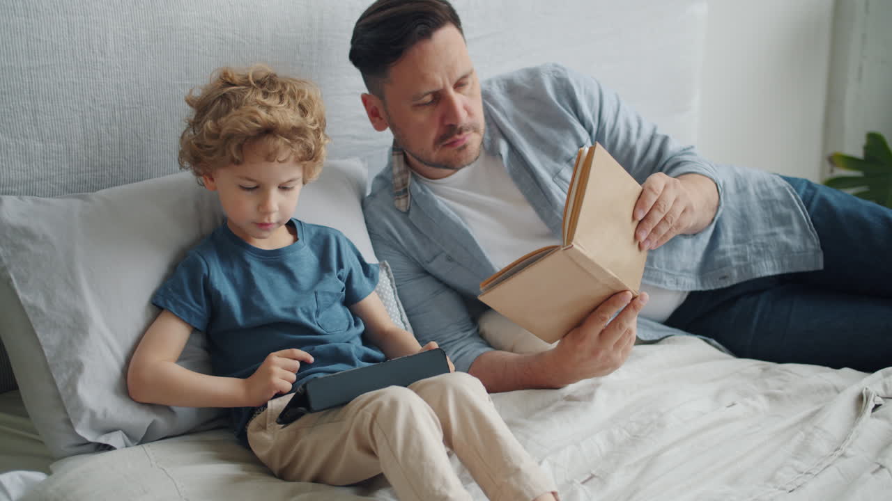 Father and Son Reading Together in Bed