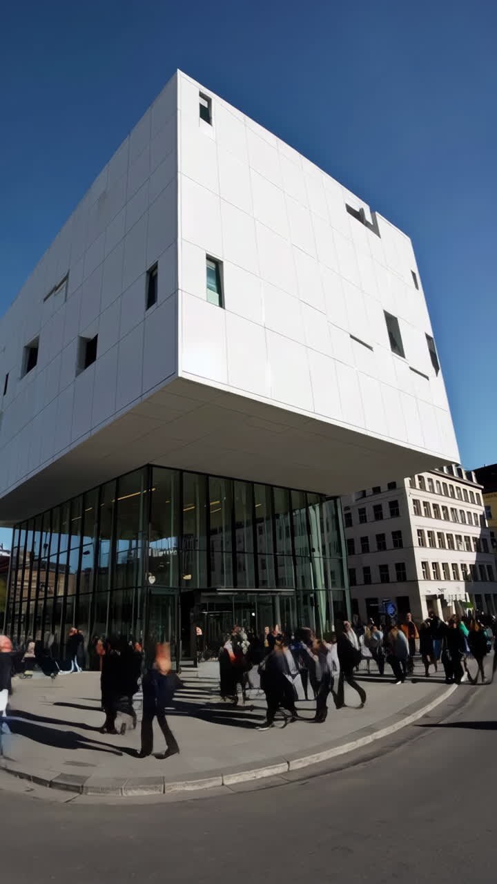 Persone che camminano fuori da un moderno edificio in vetro in una giornata di sole