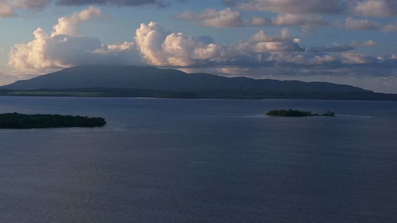 Wewak Madang Papua New Guinea aerial drone PNG tropical island sunset golden hour dusk Pacific Ocean Dogreto bay Cape Wom Yuo Mushi island remote pristine coastline harbor view clouds circle left