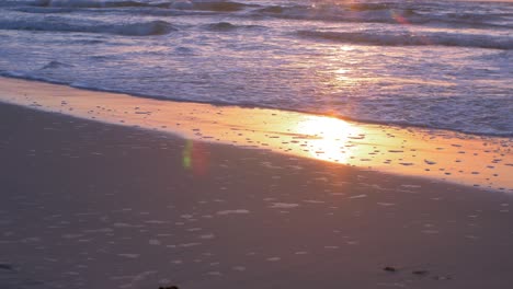 Beautiful-sunset-on-the-background-of-Baltic-sea,-sun-going-beyond-the-horizon-illuminating-water-and-clouds-in-the-sky,-calm-sea-waves,-romantic-mood,-copy-space,-low-medium-shot