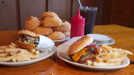 Cheeseburgers-with-french-fries-and-onion-rings-plated-with-ketchup-and-ranch,-slider-slow-motion-4K