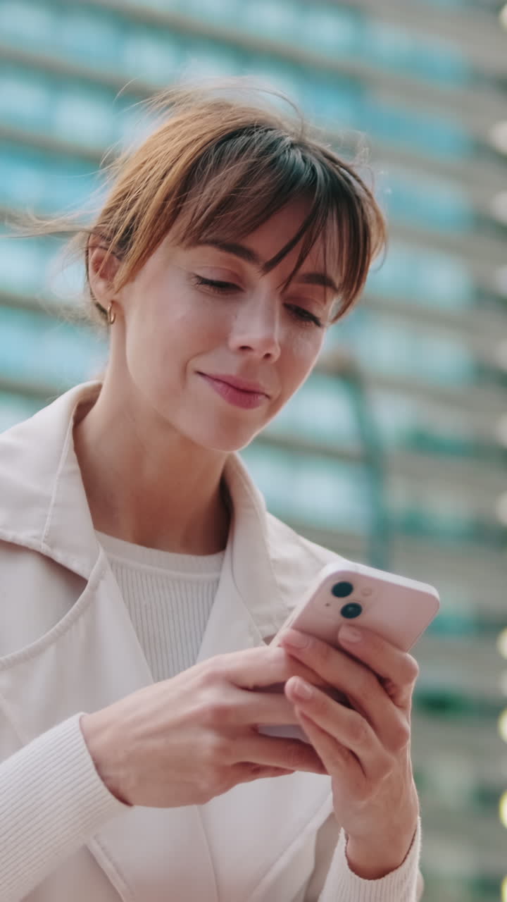 Giovane donna sorridente che usa lo smartphone all'aperto
