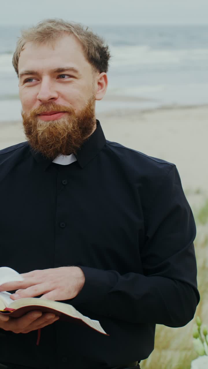 Priest Holding Bible on Beach
