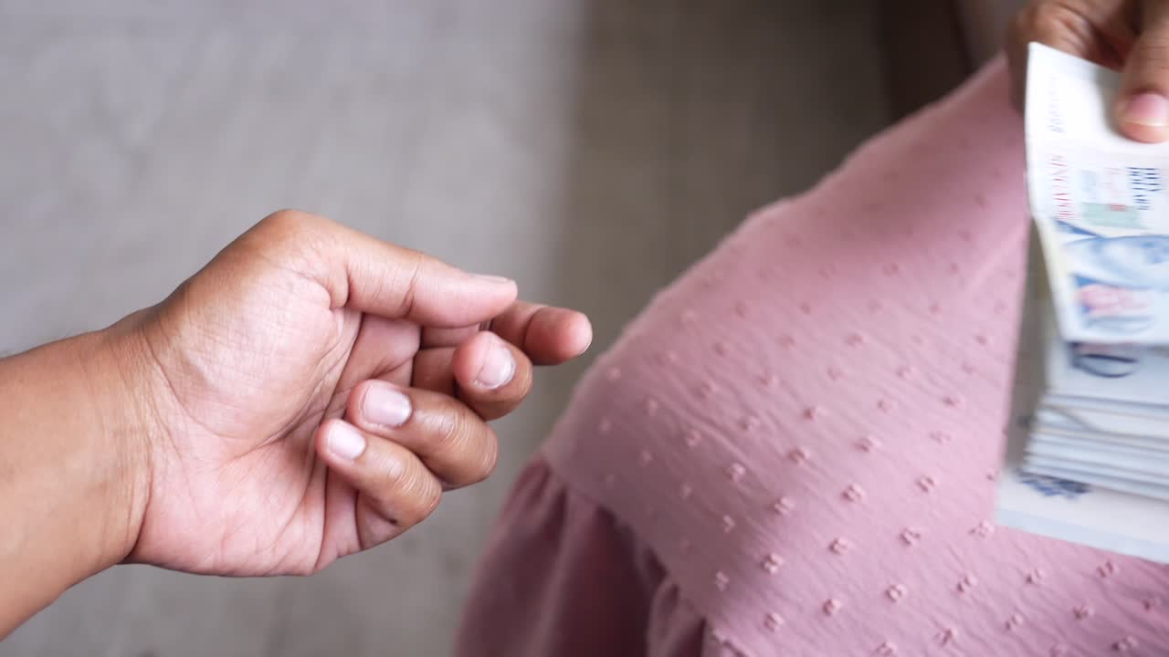 한 남자가 한 여자에게 현금 달러를 주고 있습니다.