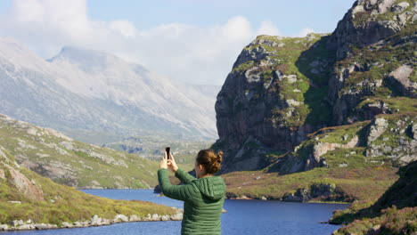 rear view of a young woman using a smartphone to