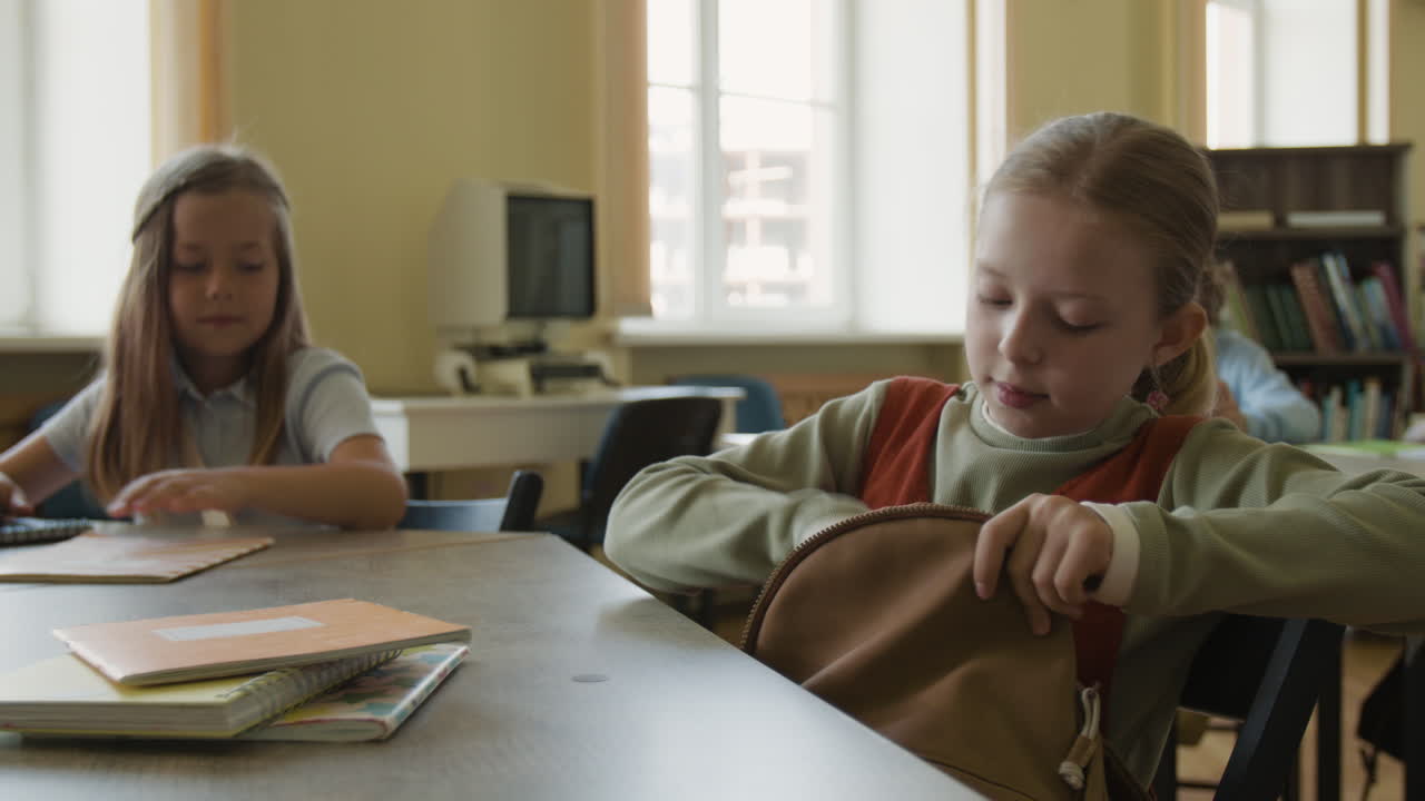 Young girls interacting and preparing for class in a school classroom or library