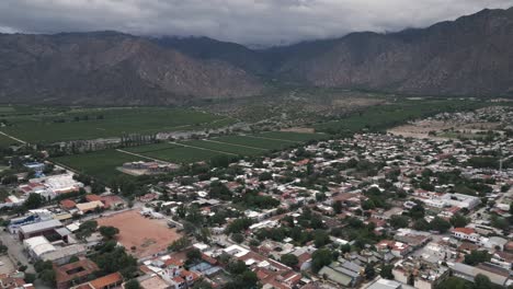 cafayate town, salta, argentina, aerial drone view of vineyard valley calchaqui, old city and andean cordillera mountain range in the background, south america