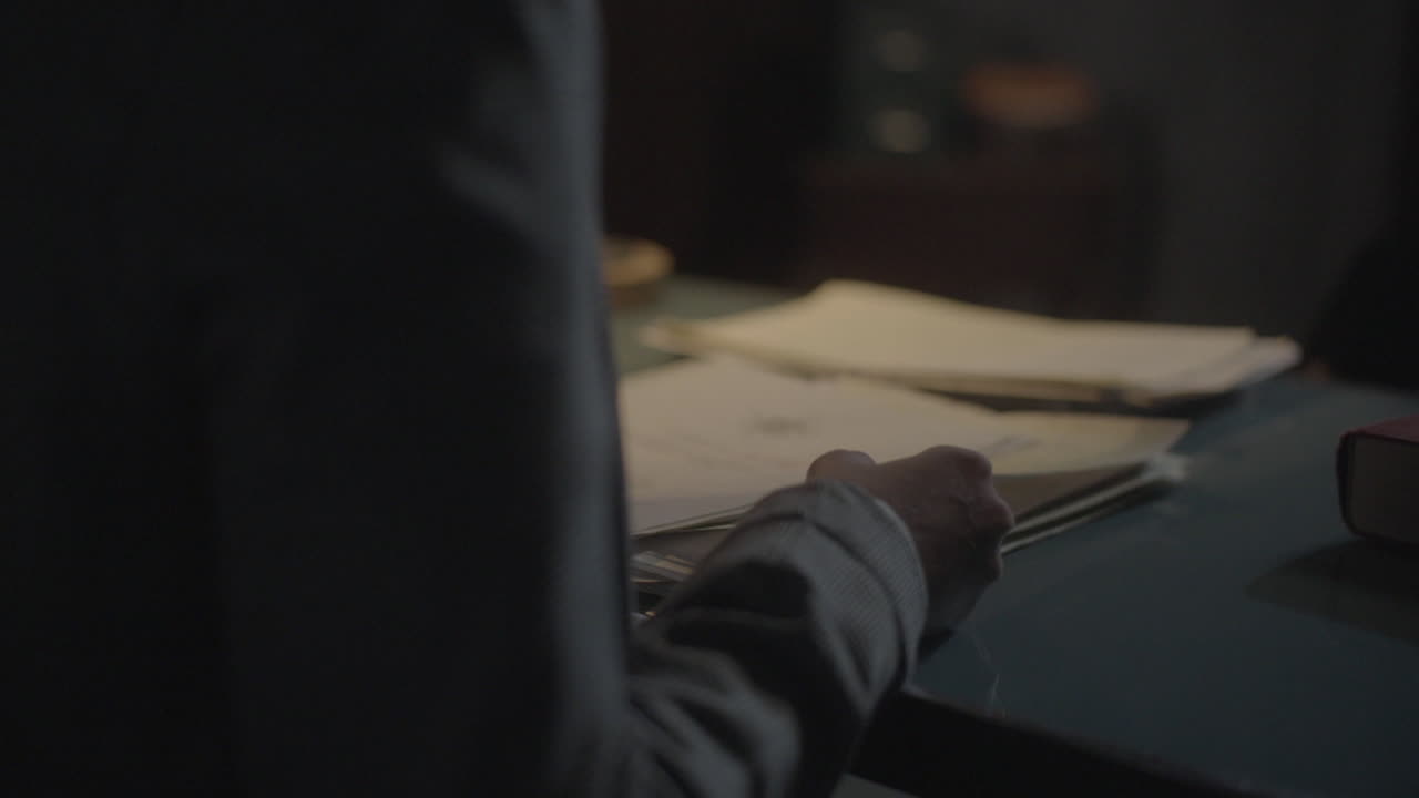 человек, рассматривающий документы за столом