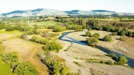 Vista-Aérea-Alrededor-De-Un-Pequeño-Arroyo-En-Un-Valle-Verde-Del-Campo-De-Nueva-Zelanda