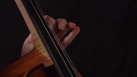 close up of woman's hand playing the cello using vibrato and trill