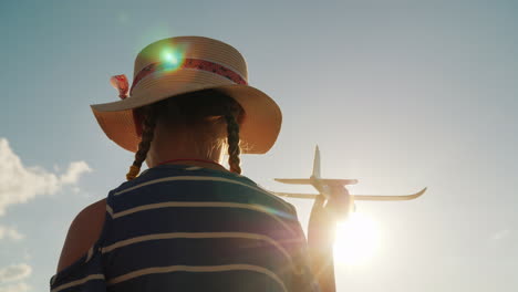 lindo niño juega con una pistola de juguete en los rayos del sol la vista trasera bebé sueña concepto 4k video