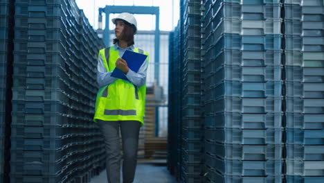 focused storekeeper checking boxes analysing pallets before shipping delivery