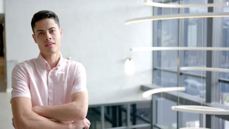 confident man in office environment crossing arms and looking at camera, copy space