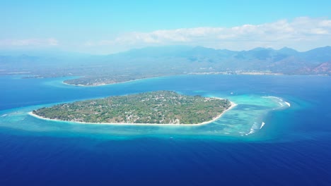 Islands-In-Hawaii---Lush-Island-Surrounded-By-Blue-Sea-Water-With-Beautiful-Mountain-Scenery-In-The-Background---Aerial-Shot